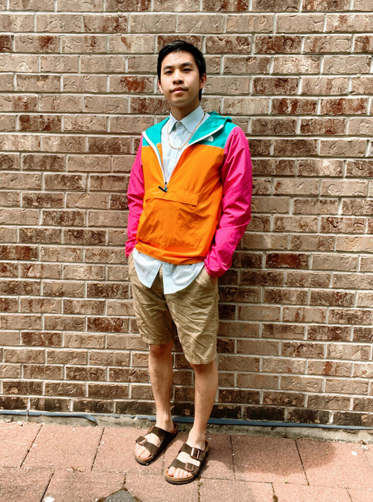 mens orange & pink windbreaker, blue button up, khaki shorts outfit
